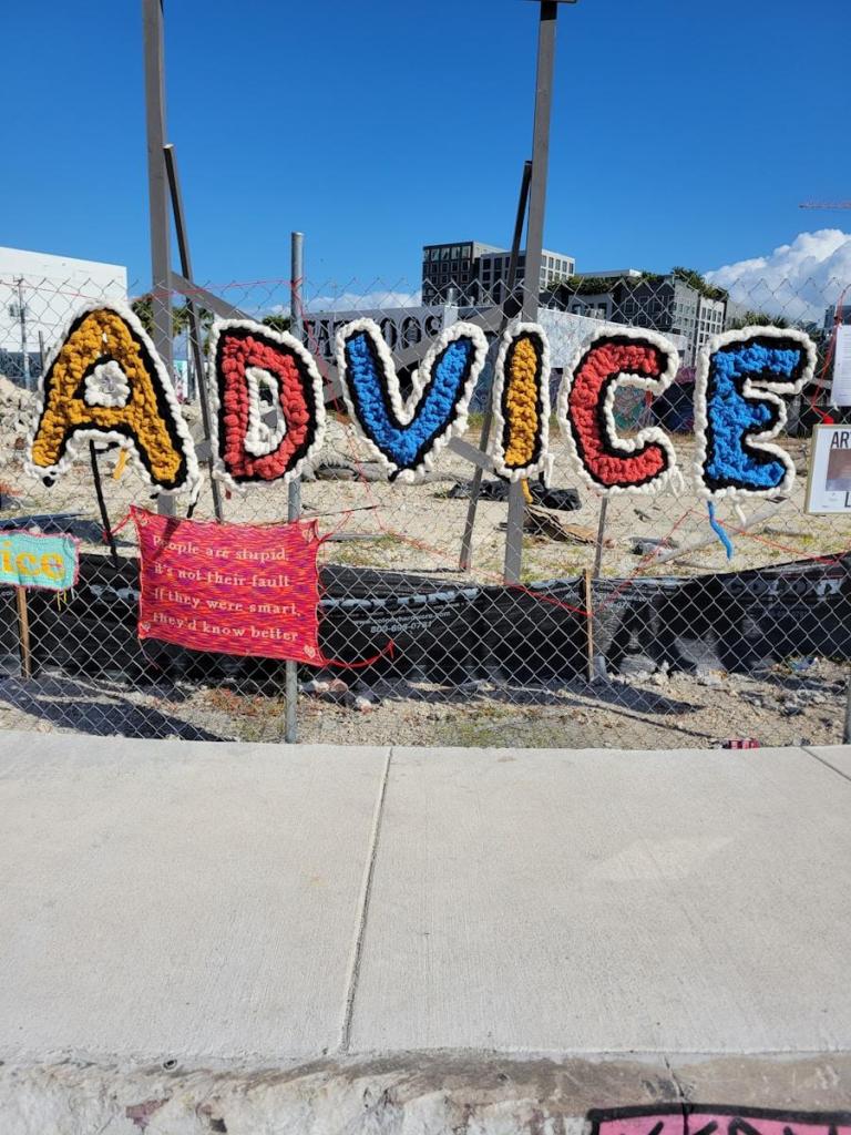 Colorful letters spell out advice on a fence.